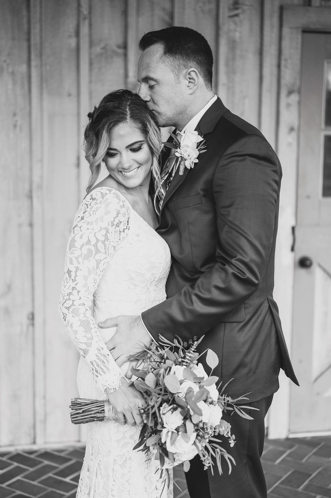 groom kissing bride on head portrait at Edel Haus alpaca farm