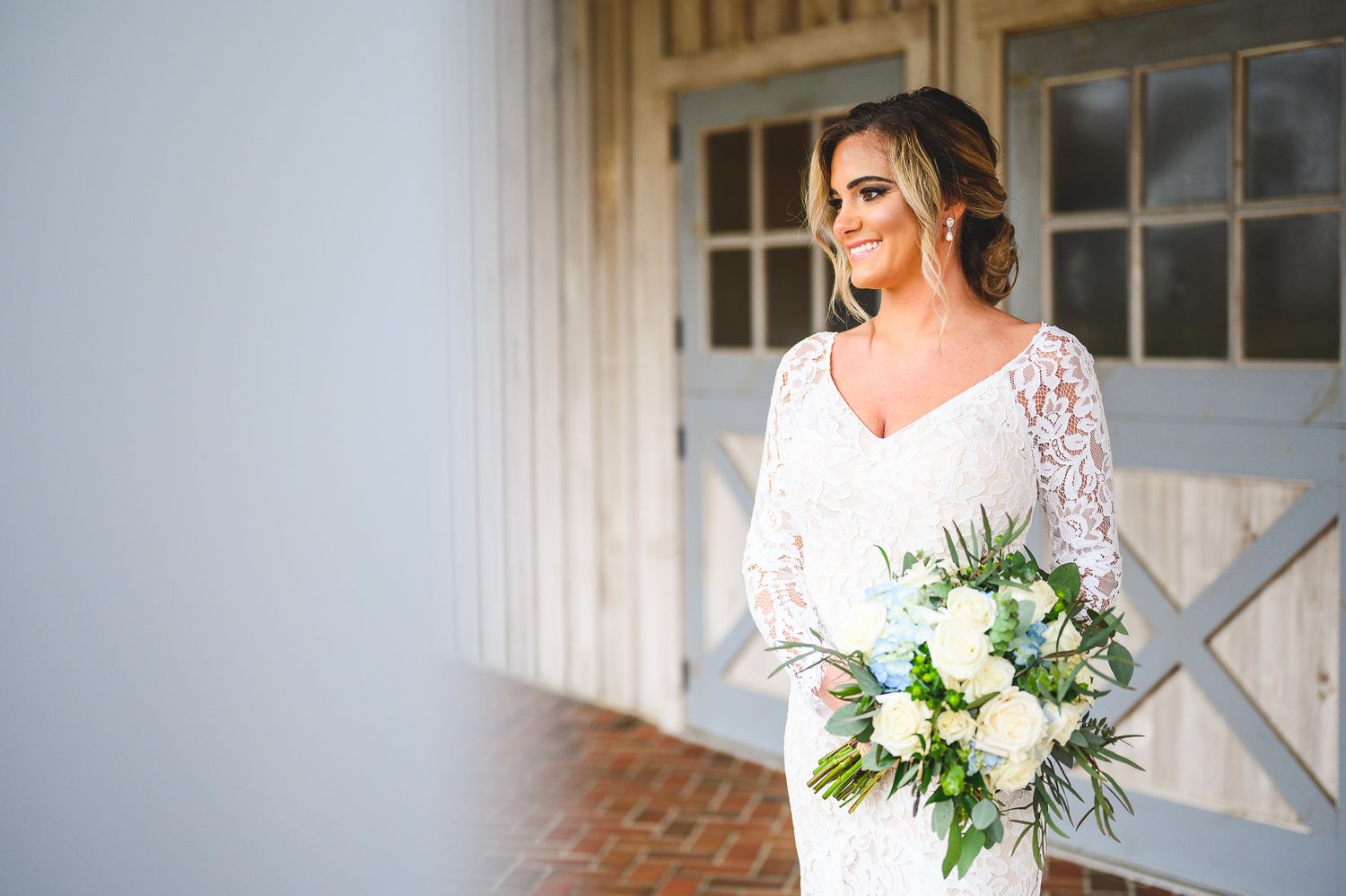 bridal portrait in front of rustic barn doors Edel Haus alpaca farm