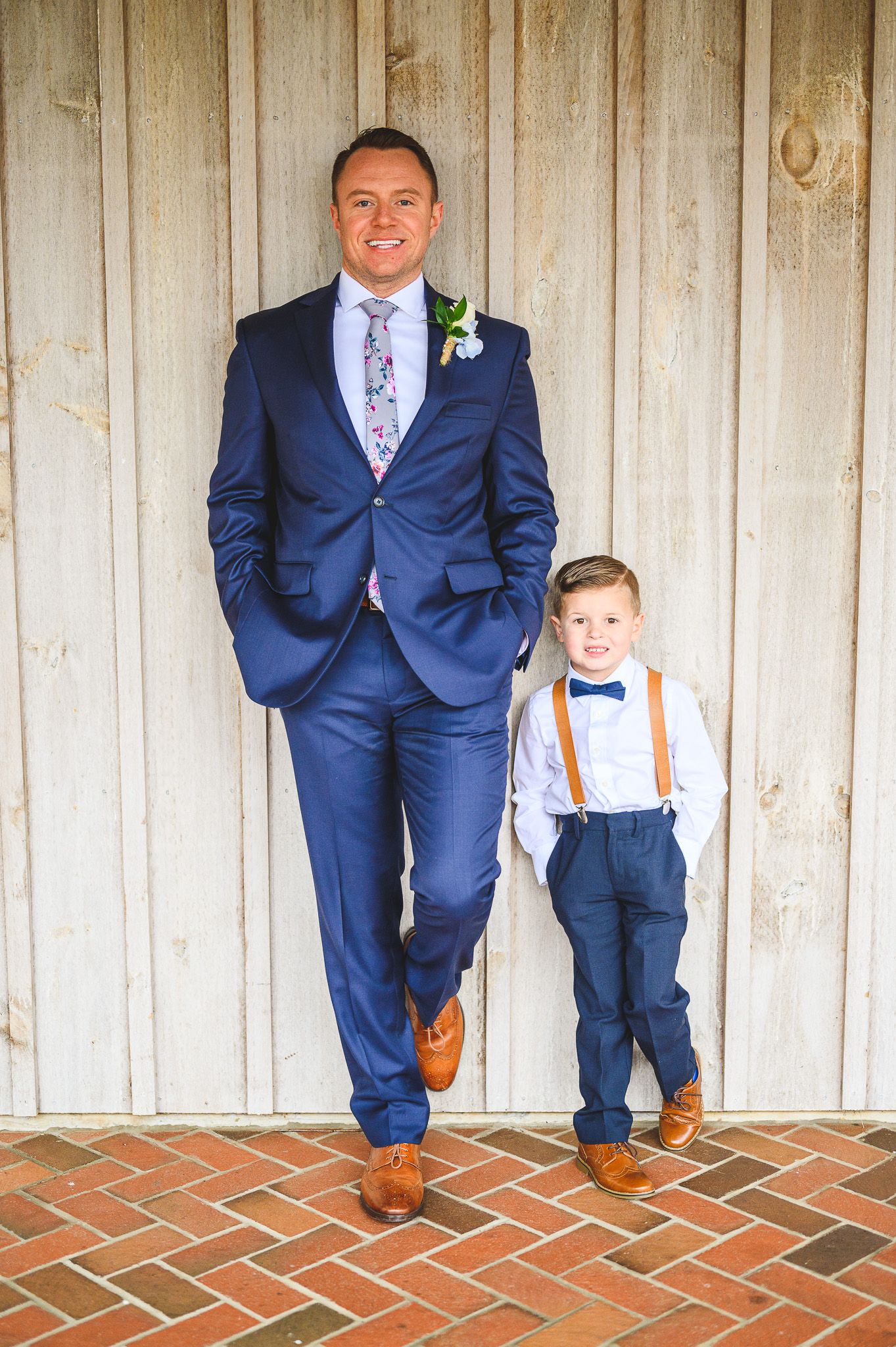 groom and son leading on barn with one leg up at Edel Haus alpaca farm