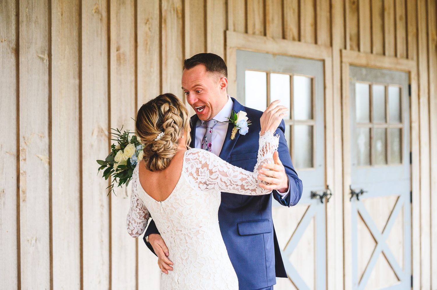 bride and groom hugging and smiling during the first look