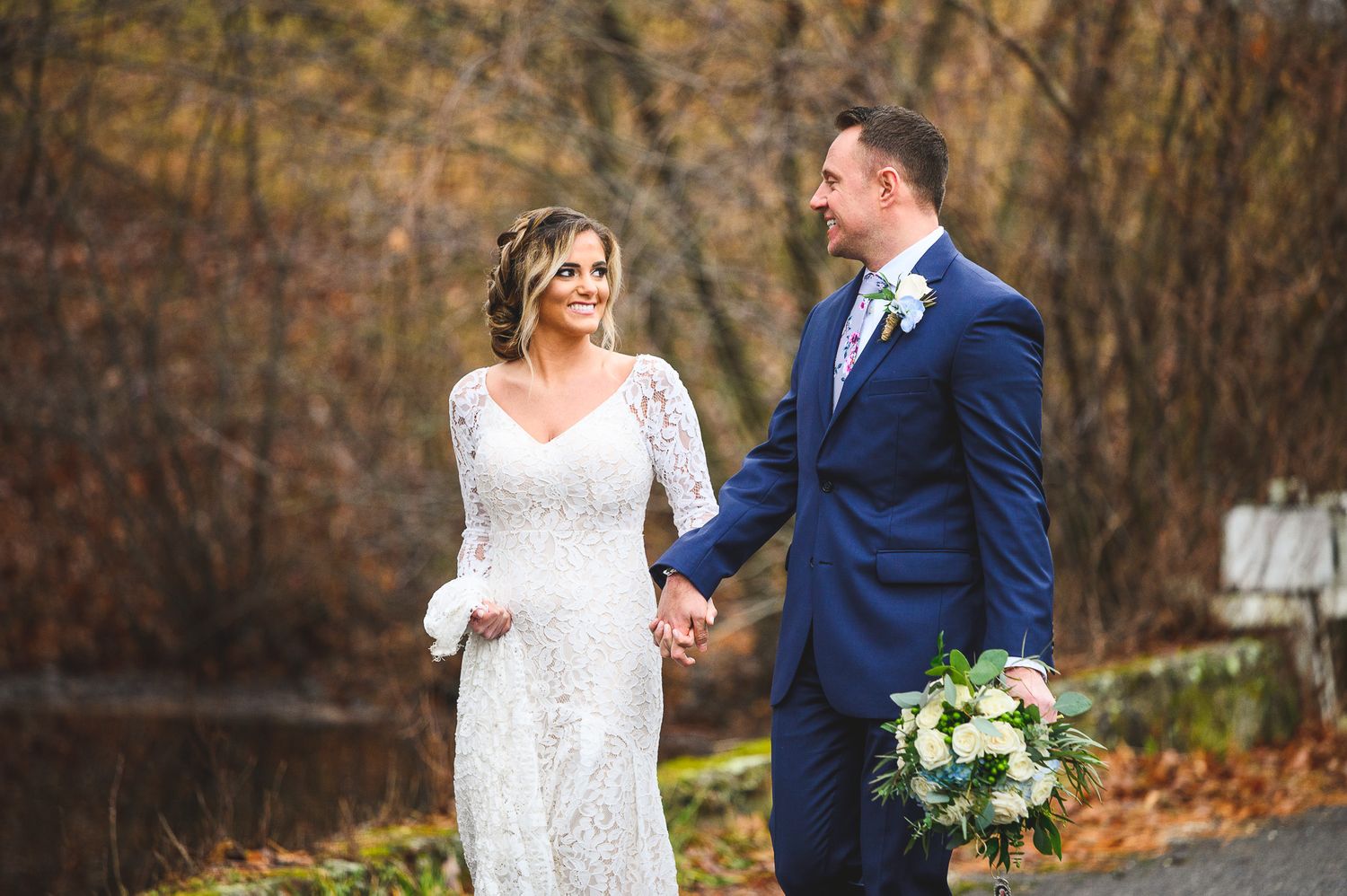 bride and groom walking over bridge at Edel Haus alpaca farm