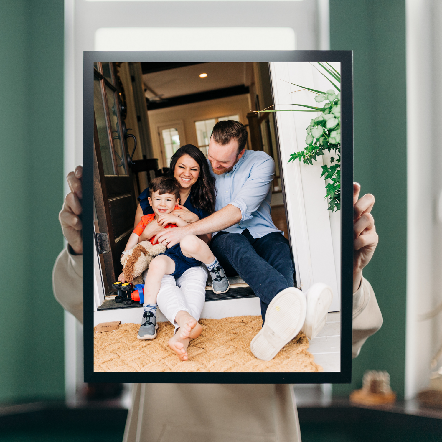 a woman holds a framed photo of a family