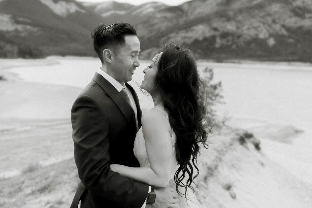 Romantic wedding portraits against dramatic mountain and lake landscape.