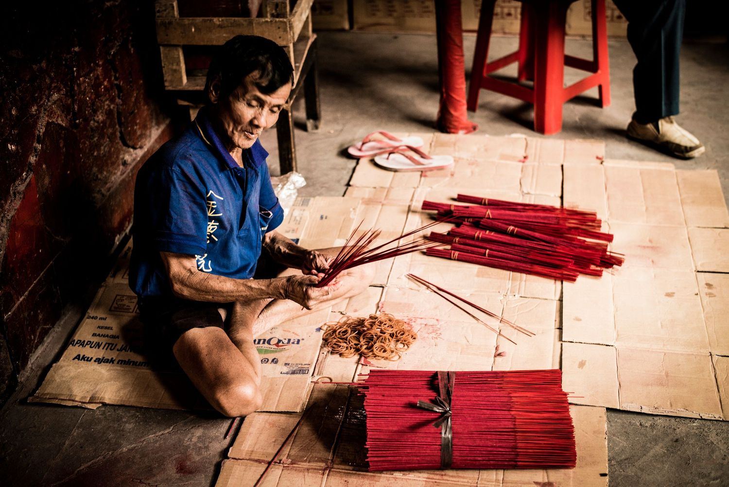Man making insense bundles in buddhist temple in Gloodok district of Jakarta Indonesia