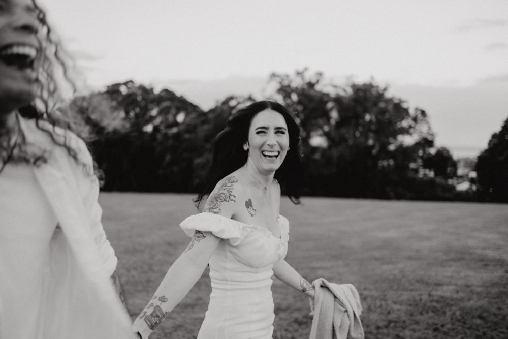 Candid black and white photograph capturing joyful moments in an open field.