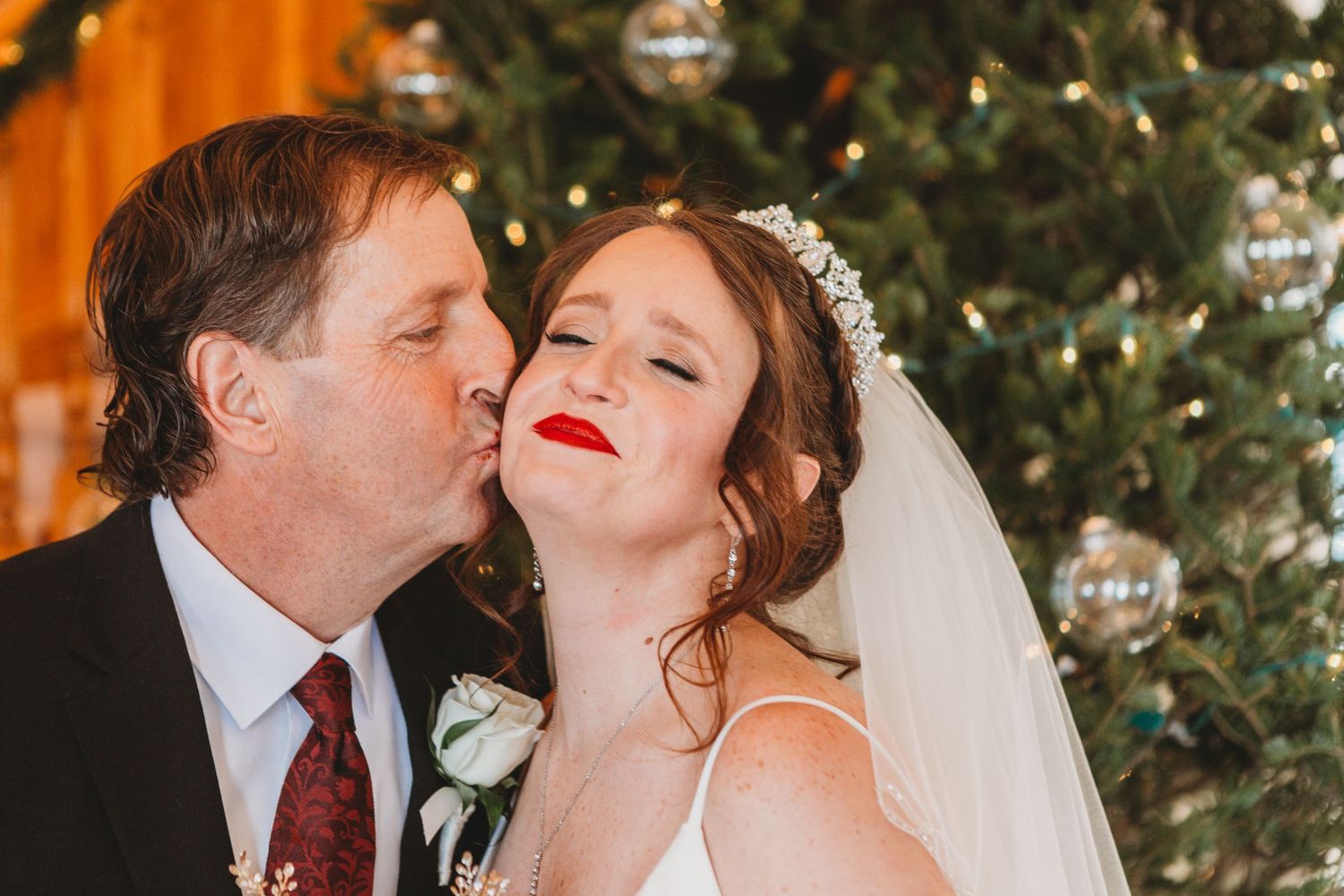 Father of the bride kisses her on the cheek during her Loveland Colorado Wedding.