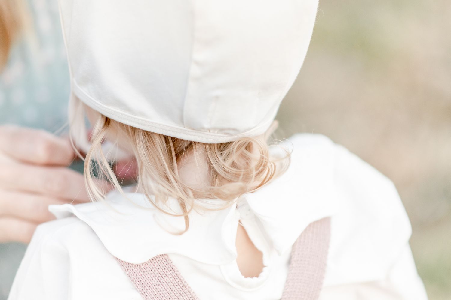 Blonde curls underneath a Briar Baby Bonnet
