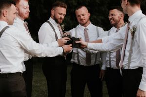 groomsmen cheers'ing with flasks