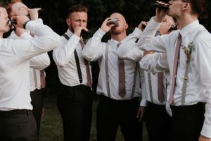 Groom and Groomsmen doing a shot out of flasks