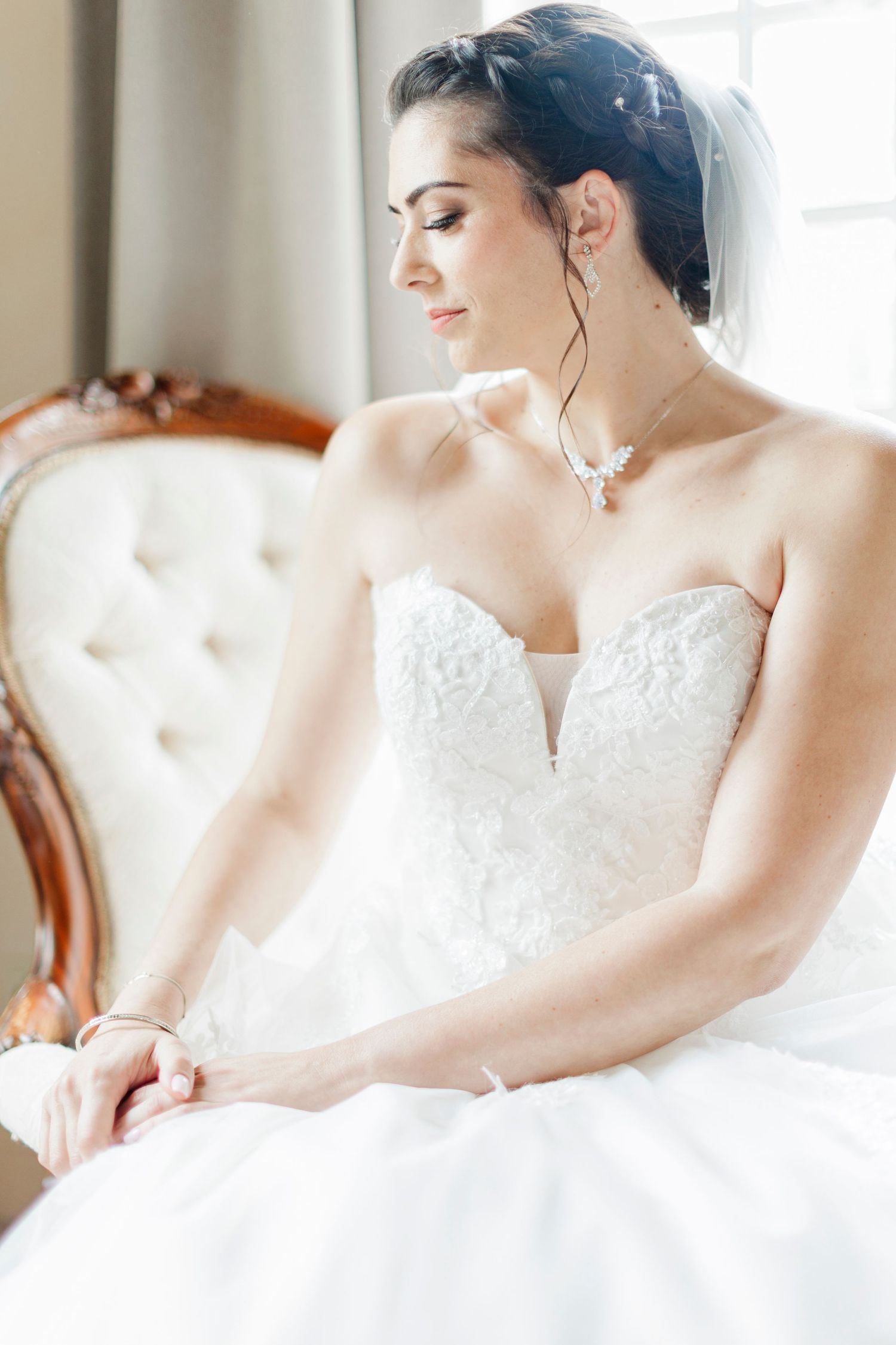Close-up bridal portrait showcasing delicate wedding day jewelry and lace details.