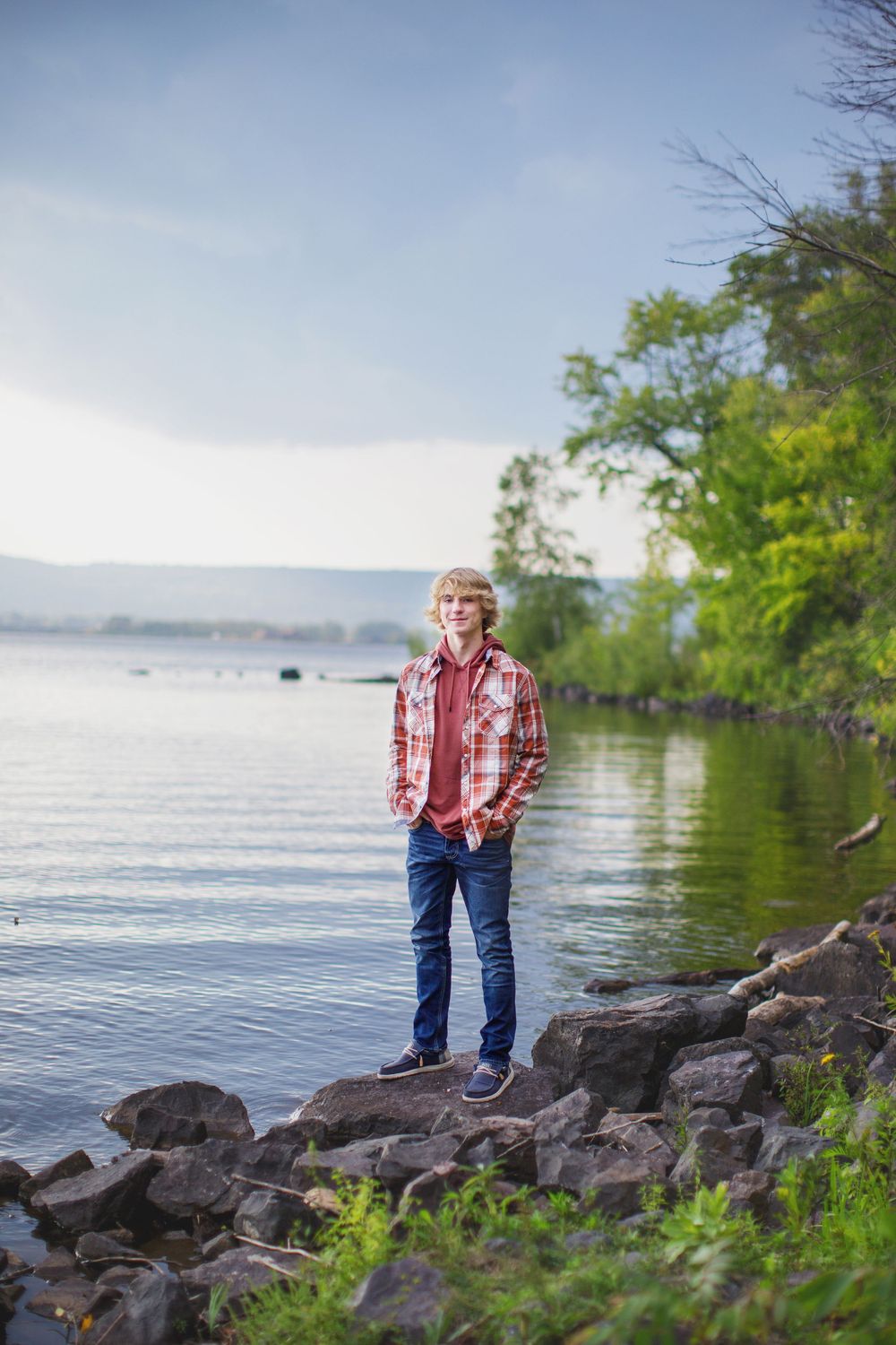 Scenic lakeside view with rocky shoreline and green trees in spring.