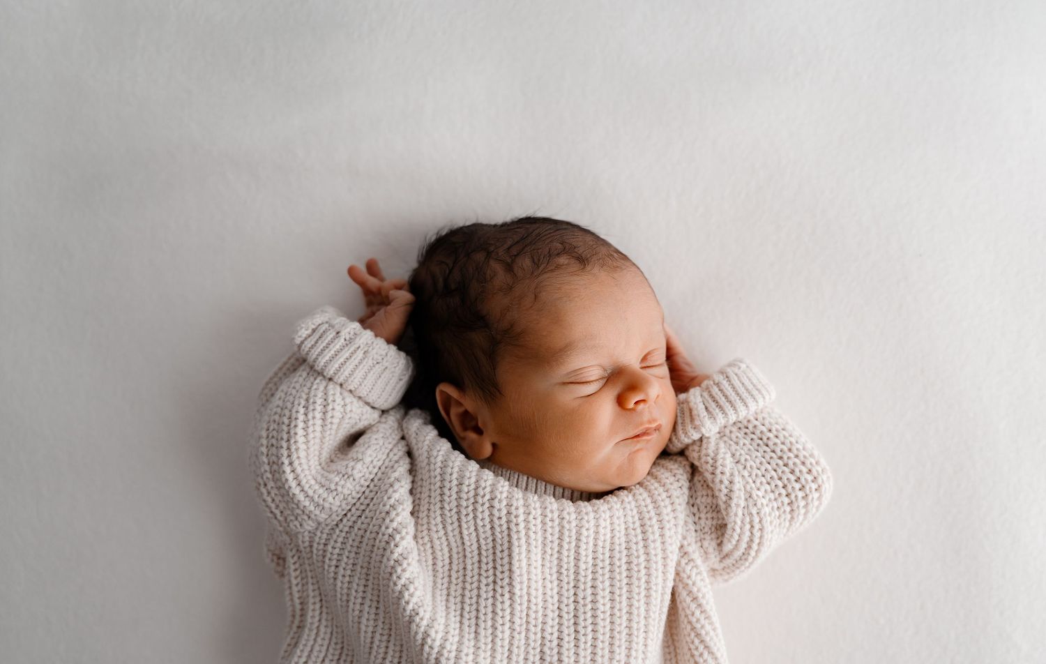 Minimalist newborn photography against white background showing peaceful sleeping poses.