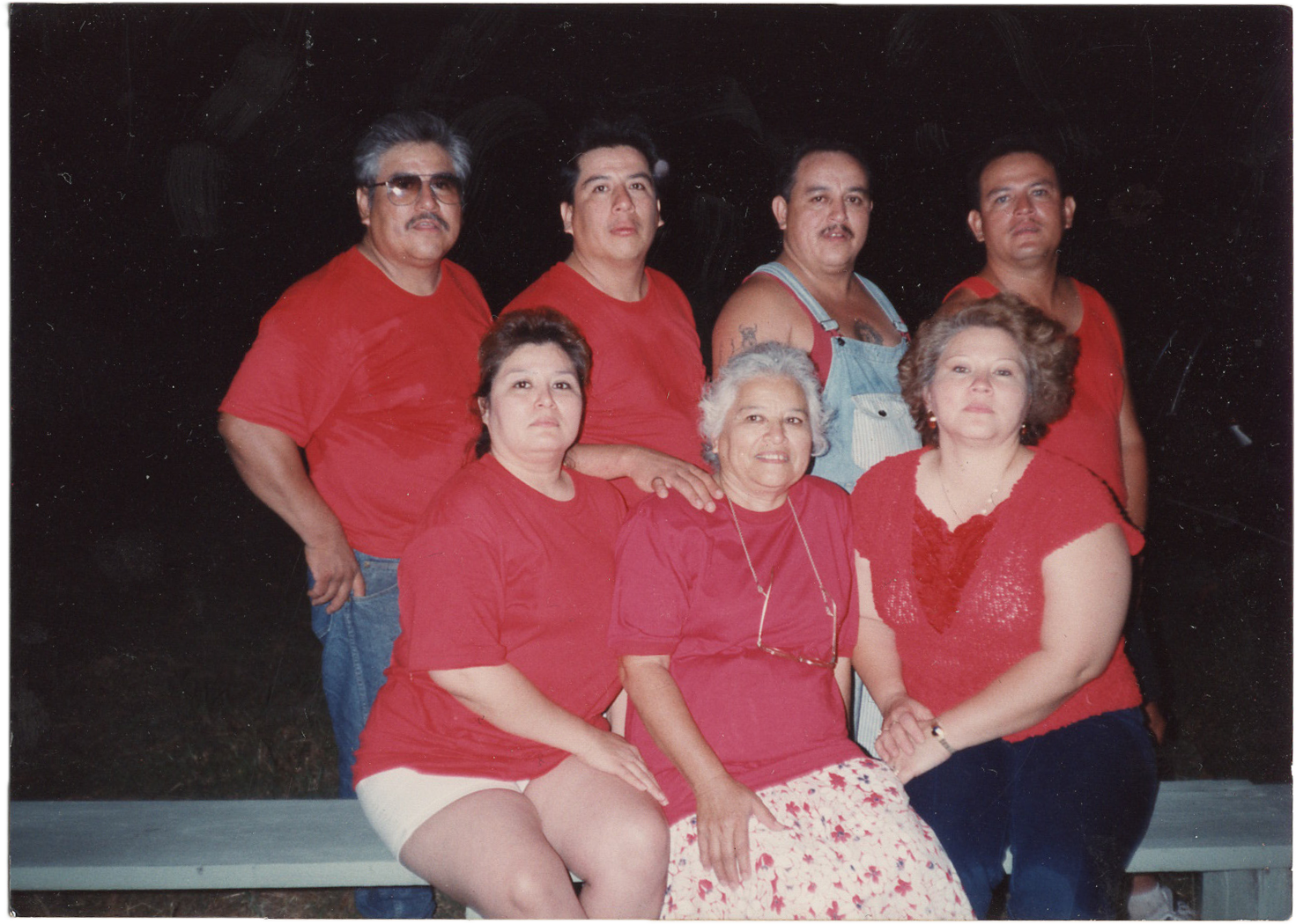 A group of people wearing red shirts posing together for a casual group photo.