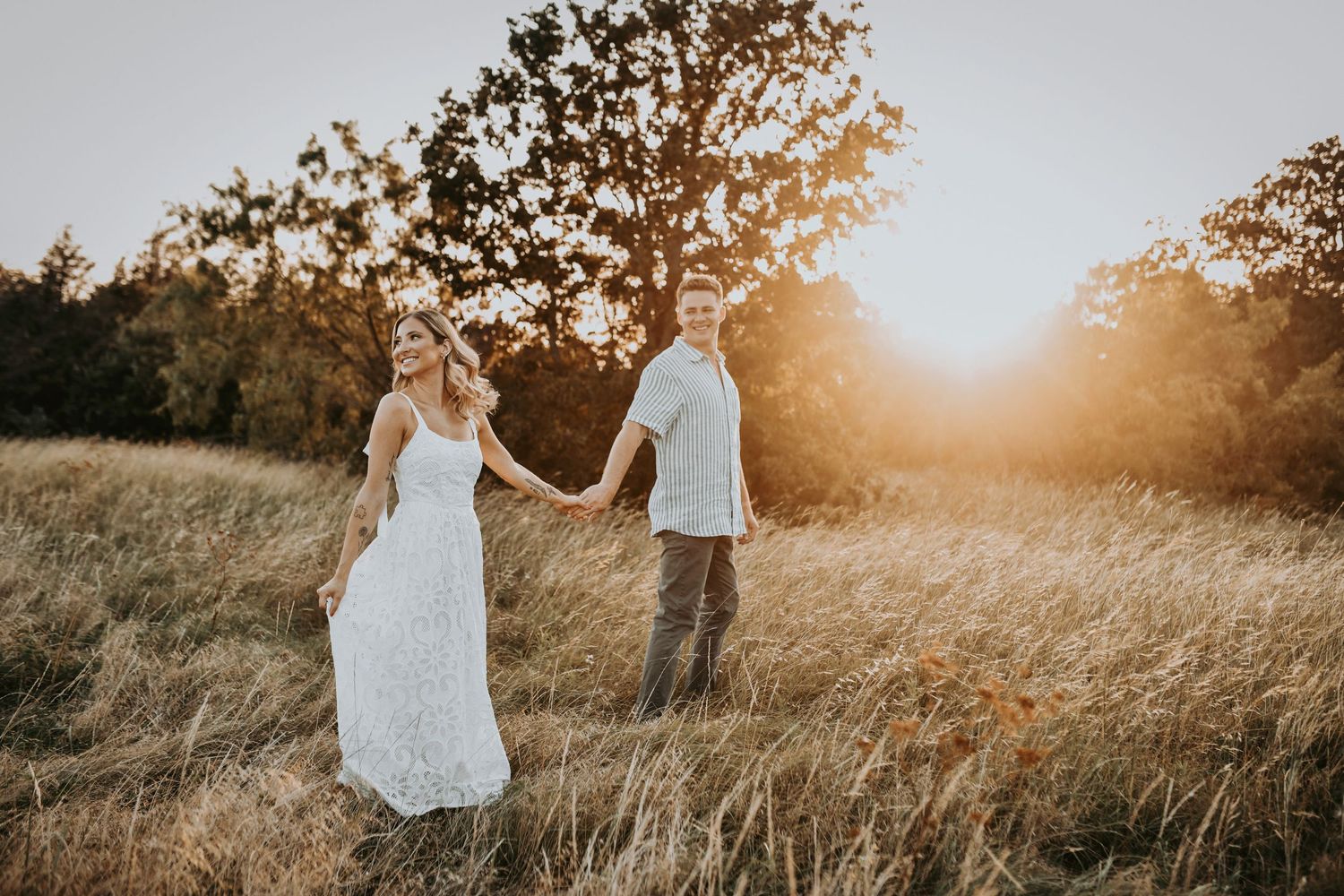 Groom-to-be dipping his fiancée under glowing Texas skies in golden grass