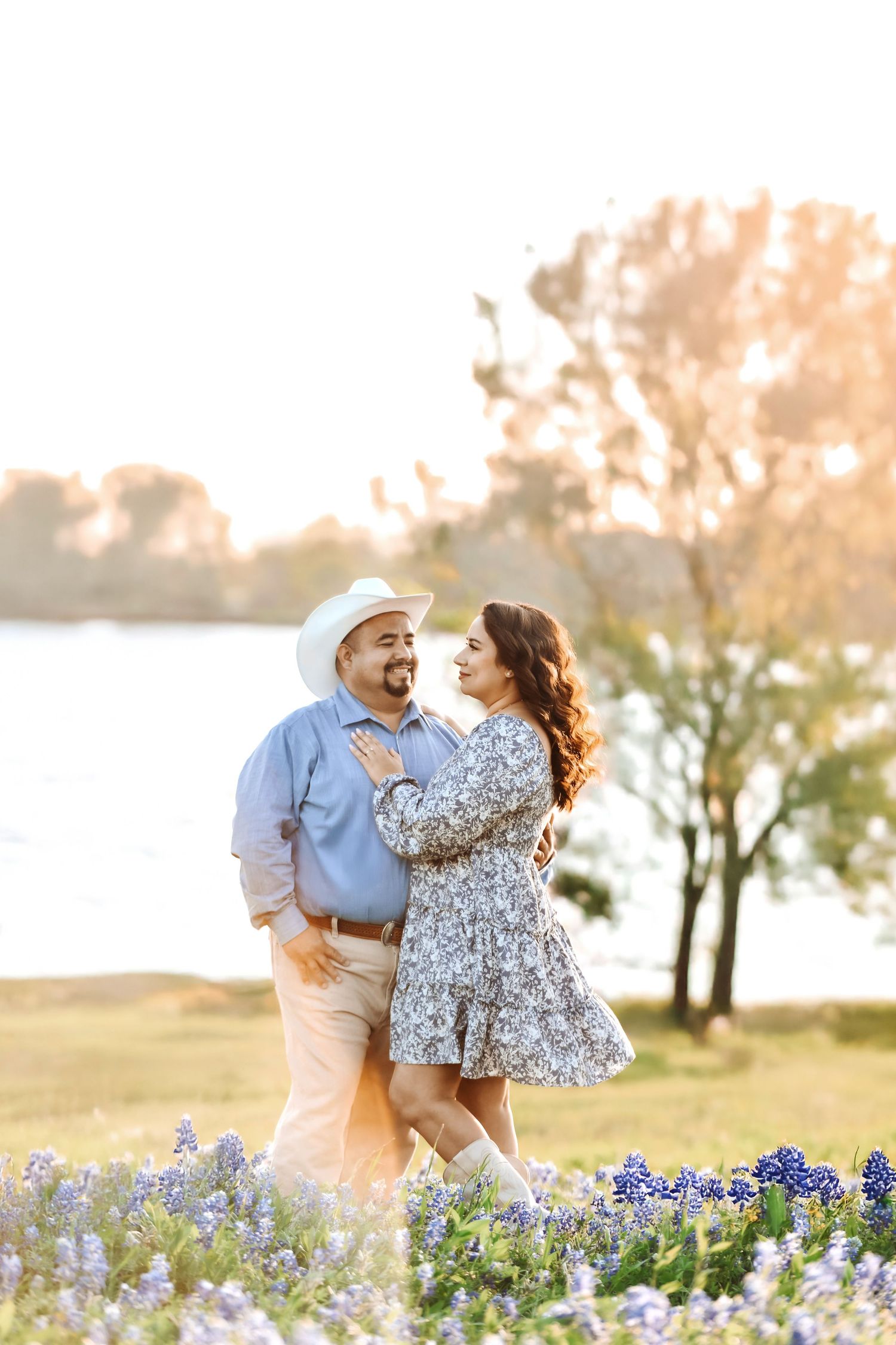 Couple nose-to-nose in a field of Texas wildflowers with soft lake breeze rustling the blooms