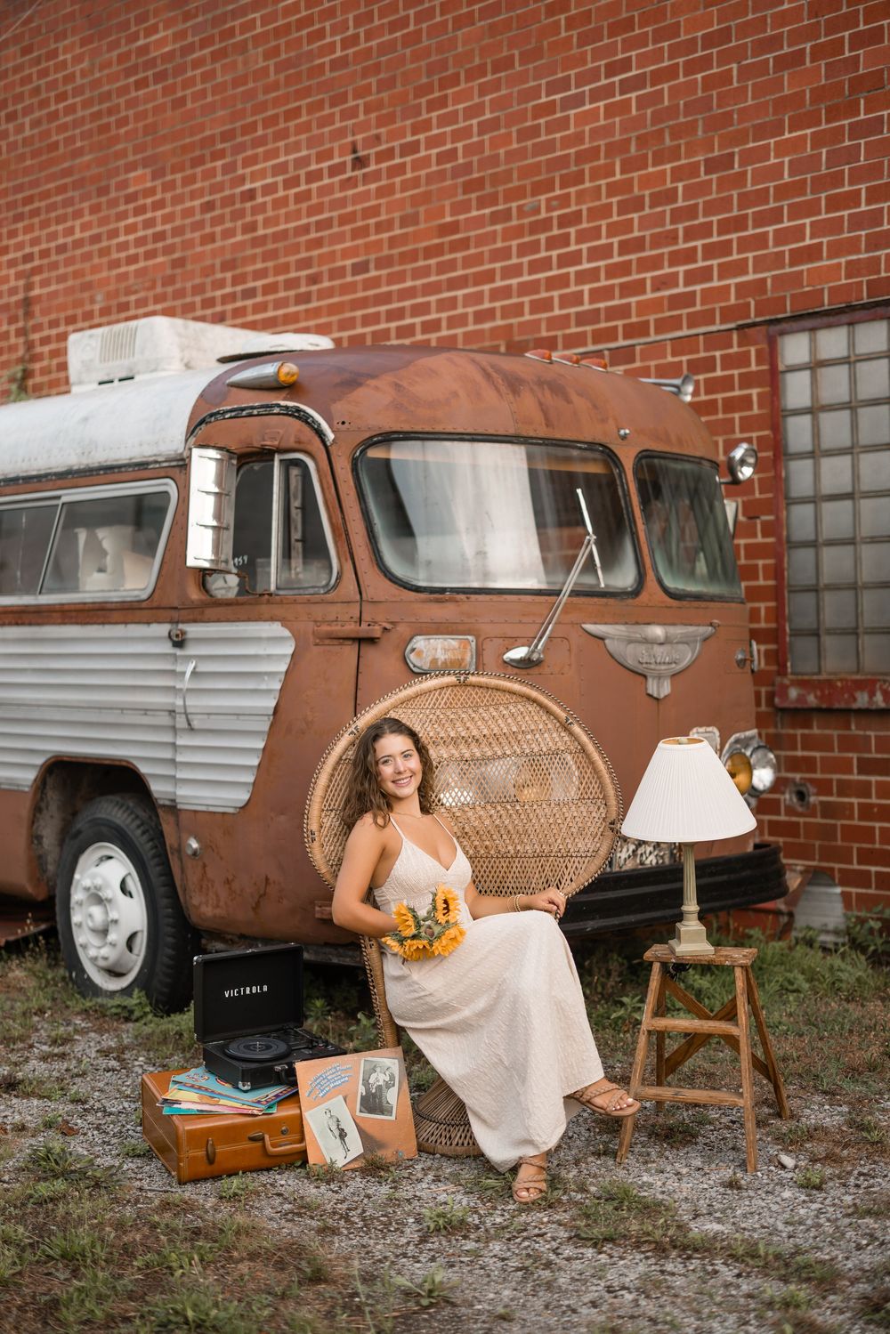Vintage brown pickup truck against brick wall provides rustic backdrop for outdoor portrait session.