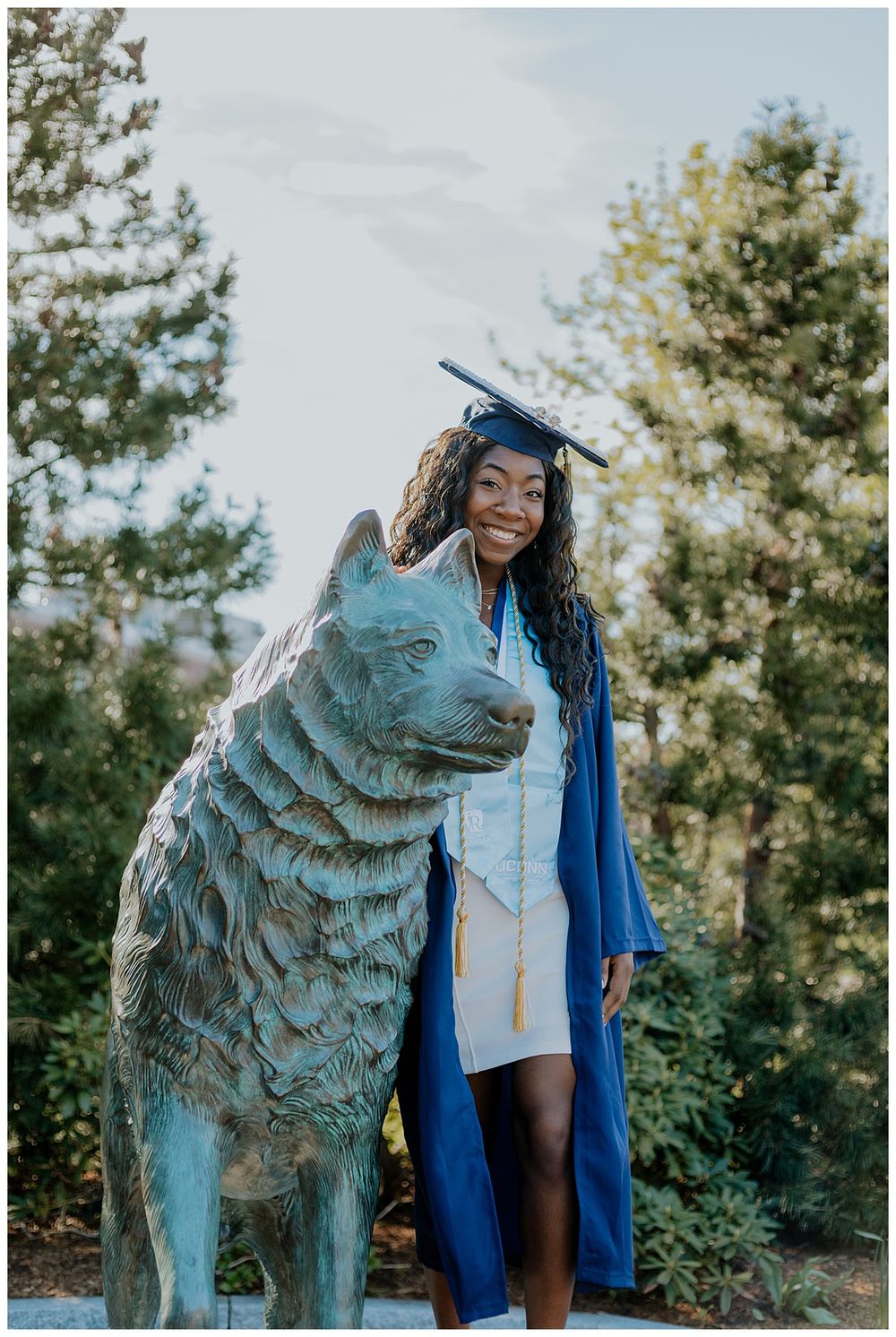 female senior posing with Jonathon the husky statue