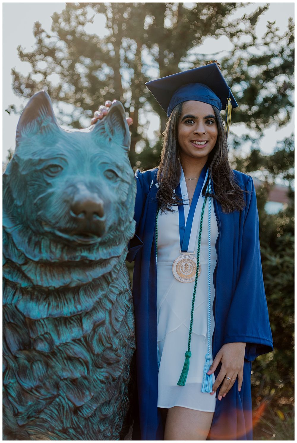 female senior posing with Jonathon the husky statue