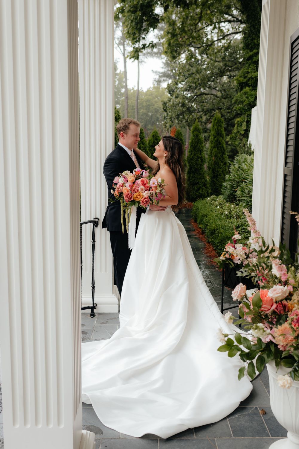 a bride and groom stand outside the lumpkin house in albertville, alabama on their wedding day, right after their first look