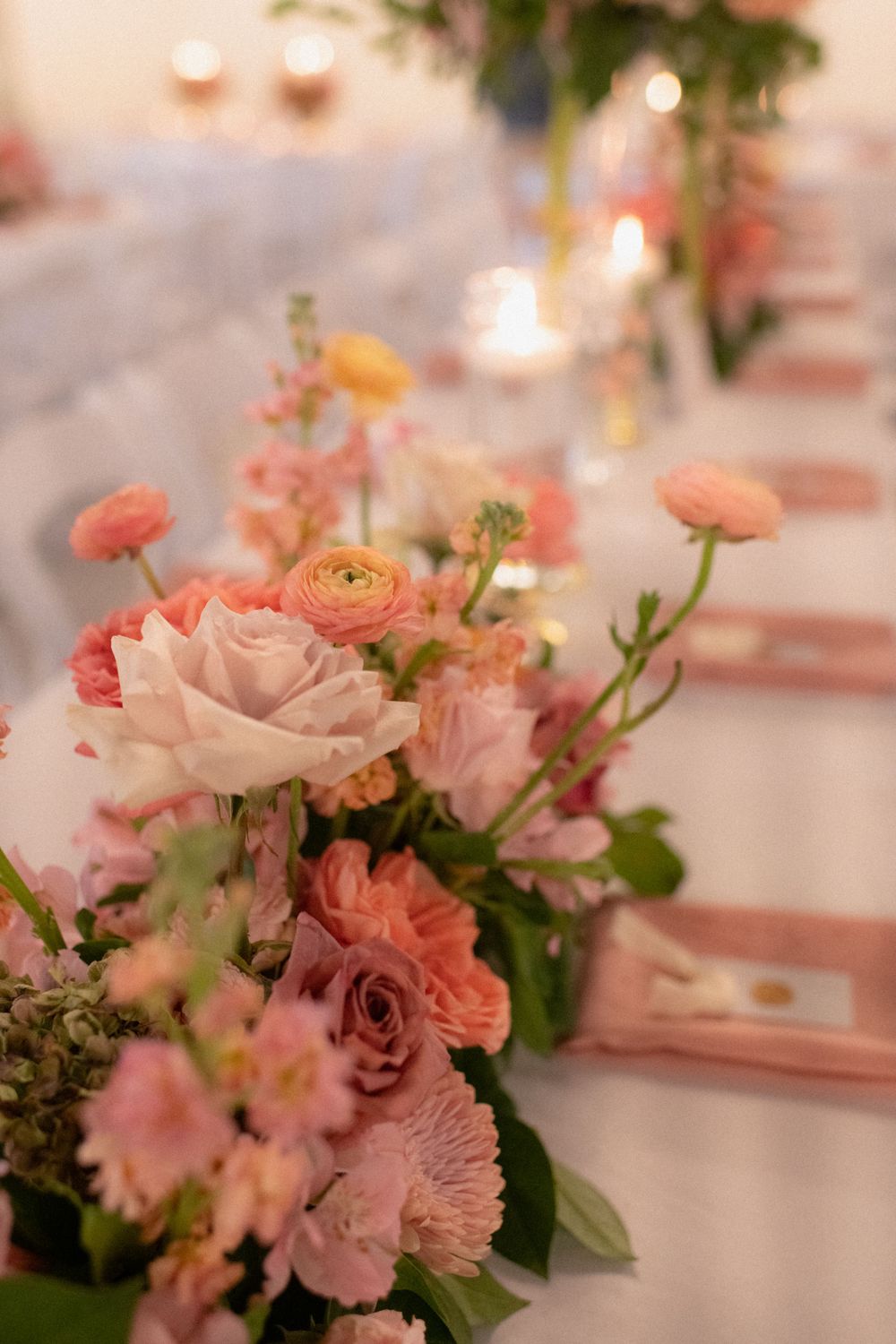 wedding florals and candles at a table during an indoor wedding reception in the banquet hall of the lumpkin house wedding venue