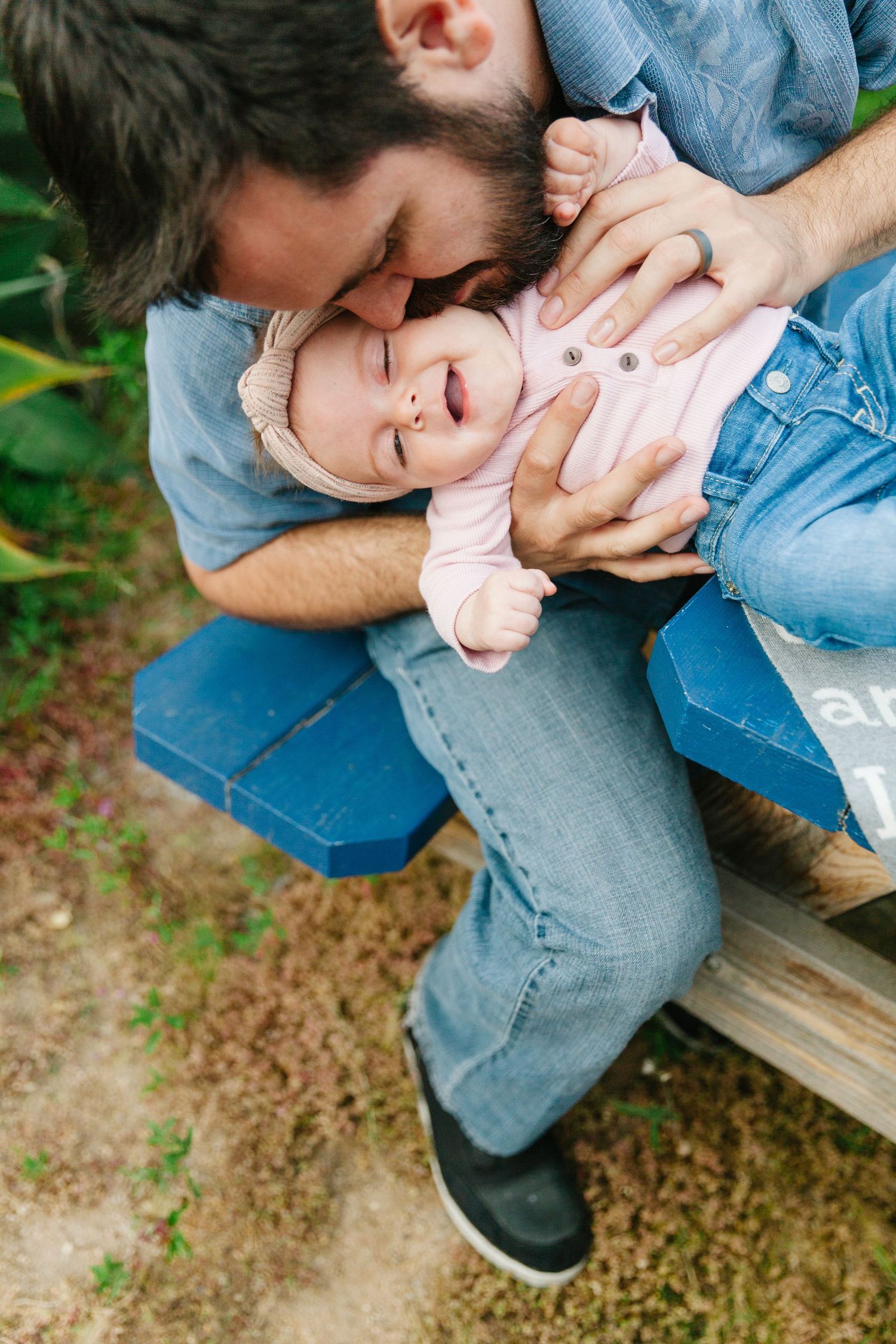 dad kissing his baby on the cheek while she smiles