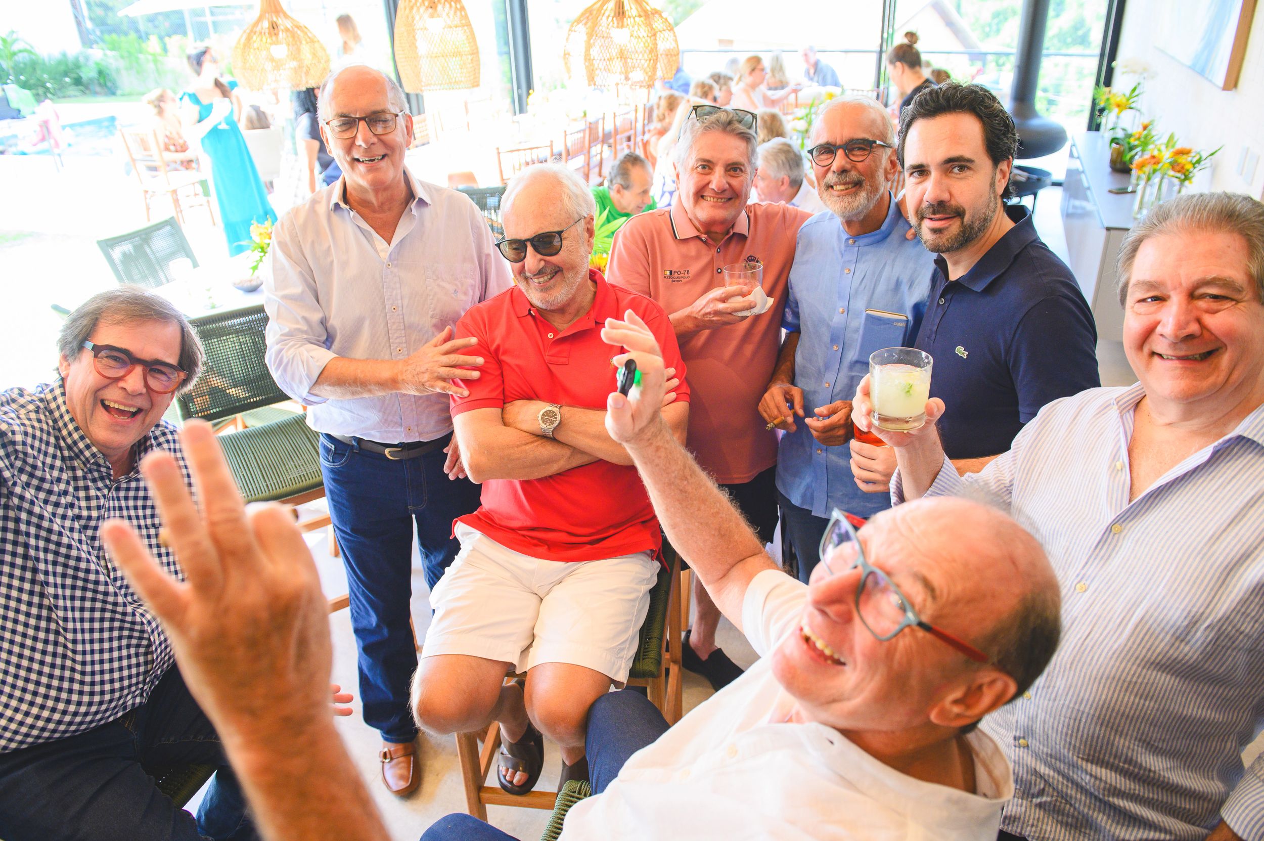 A group of people enjoying drinks and laughing together at a casual outdoor gathering.