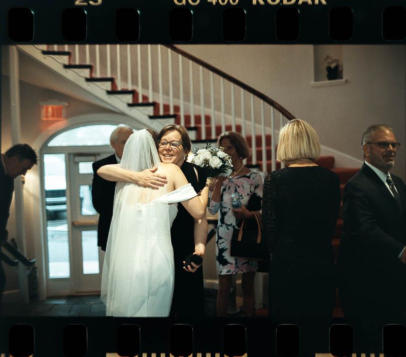 Two people hug at wedding celebration at Christ First Church Fox Chapel Pittsburgh PA shot on 35mm Film SLR by Eternal Lens Media