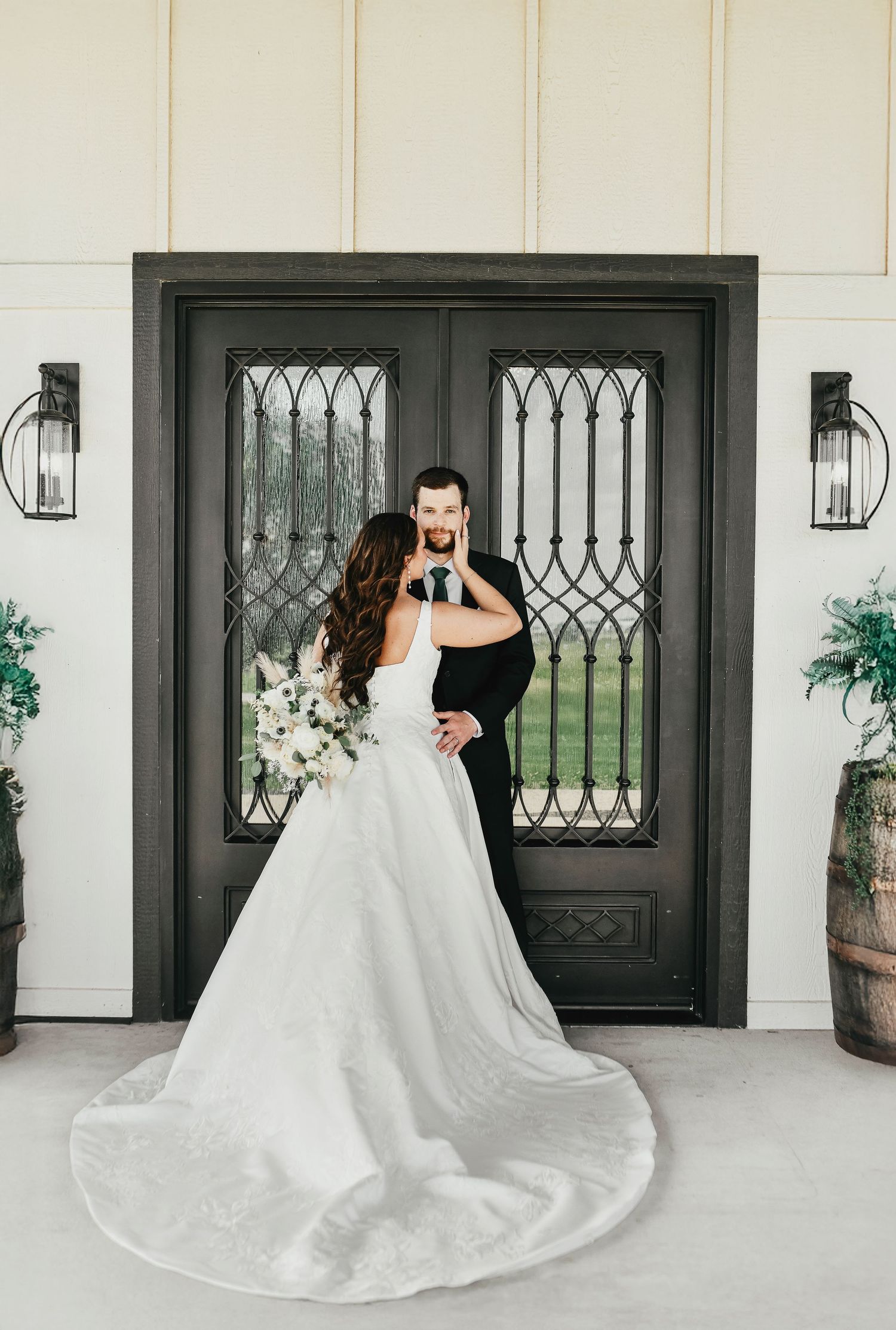Chic wedding couple photo with farmhouse barn doors behind