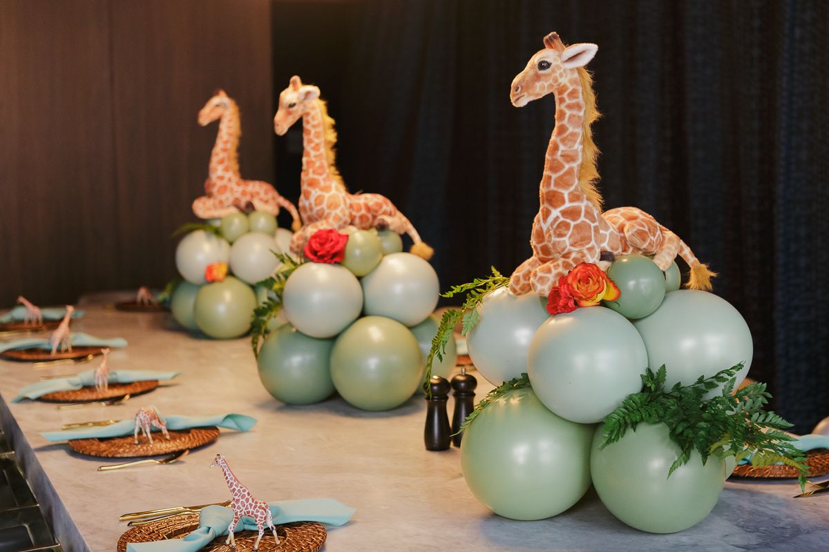 Stylish giraffe and balloon centerpieces adding a whimsical safari touch to an upscale Manhattan baby shower celebration