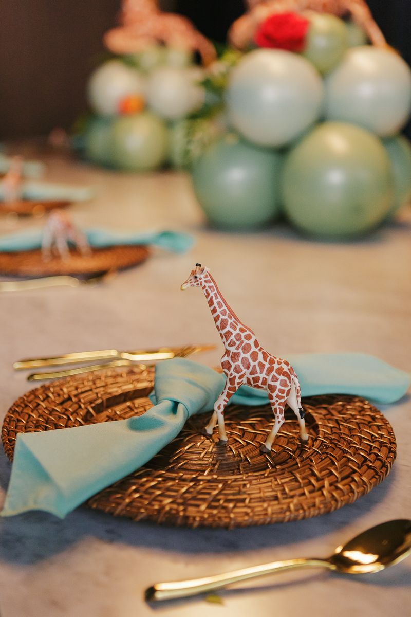 Elegant South African safari-themed plate setting featuring a tiny giraffe figurine, captured at a luxury baby shower in Manhattan’s FiDi