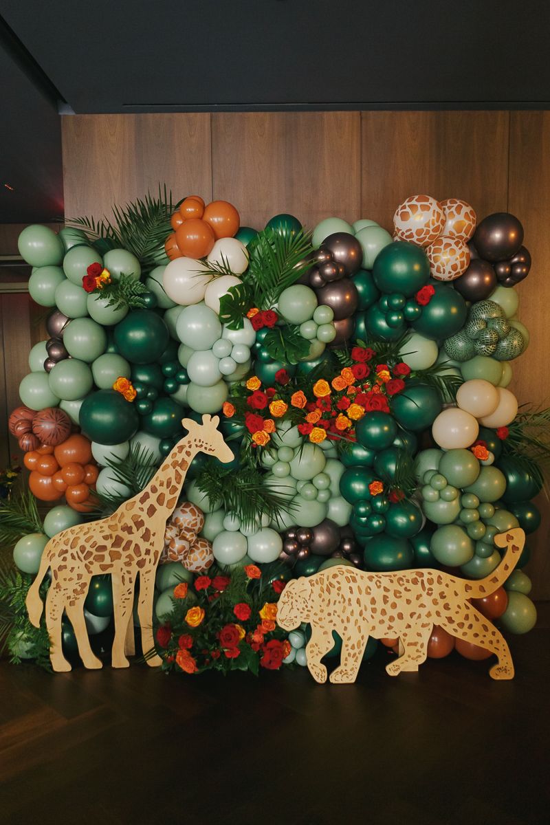 Stunning safari balloon wall with a wooden giraffe accent, creating an immersive South African-inspired atmosphere