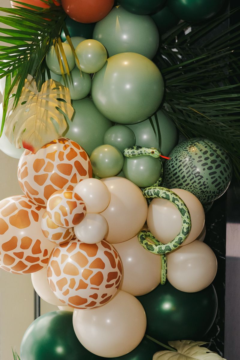 Playful safari detail—a stuffed snake emerging from a vibrant balloon arrangement at an elegant Manhattan baby shower