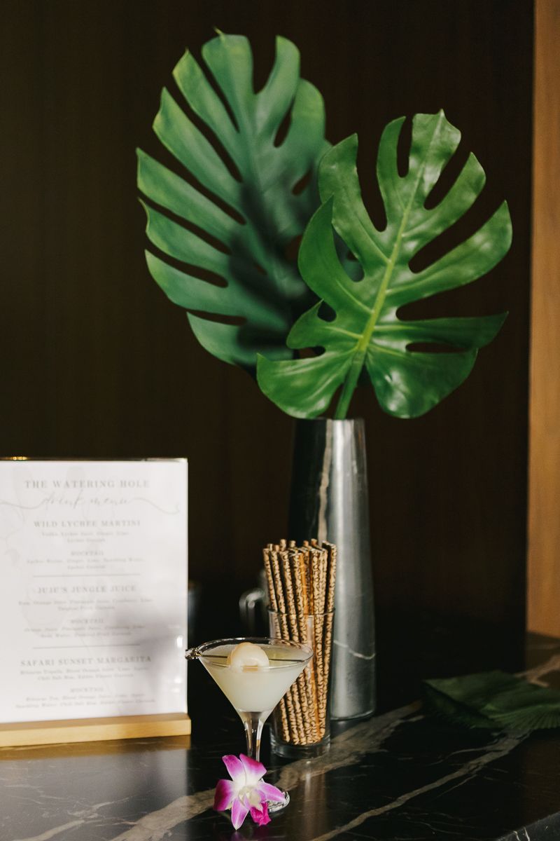 Sophisticated bar setup adorned with lush safari-inspired floral arrangements, enhancing the ambiance of a high-profile baby shower.