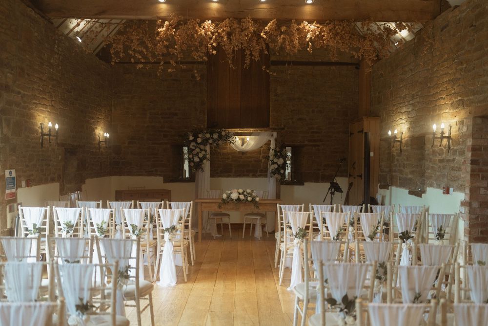 Elegant rustic wedding venue with white chairs and stone walls at Crockwell Farm wedding