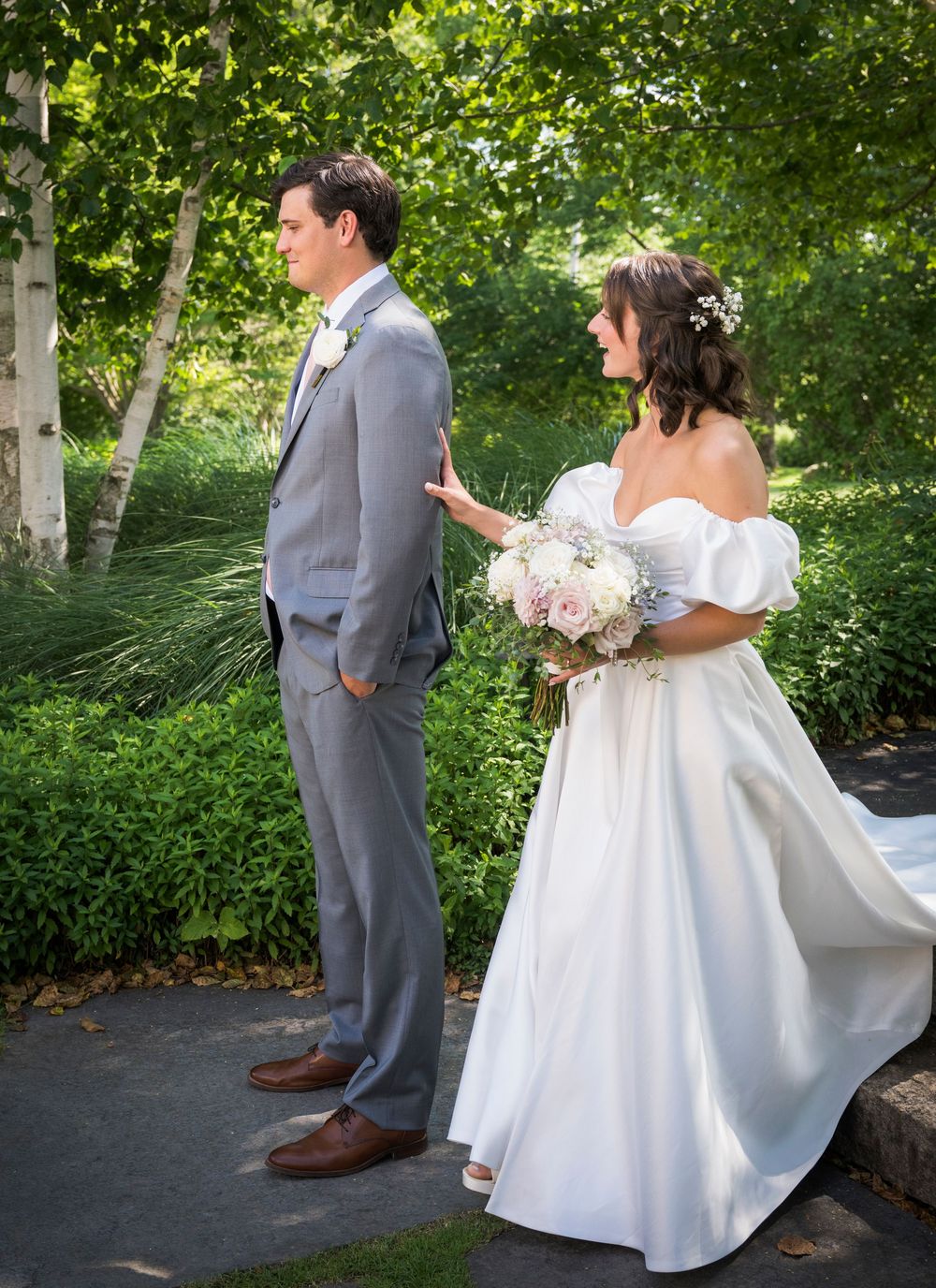 A couple shares their first look before their wedding ceremony in a lush garden setting.