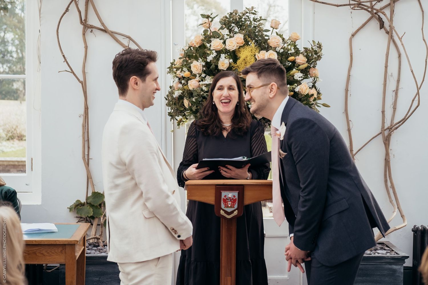 A wedding couple sits intimately together on ornate marble stairs with a white bouquet in a romantic moment.