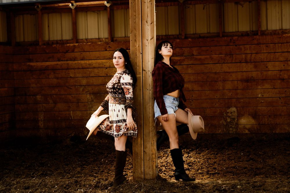 Artistic barn photoshoot featuring cowboy boots and rustic wooden backgrounds.