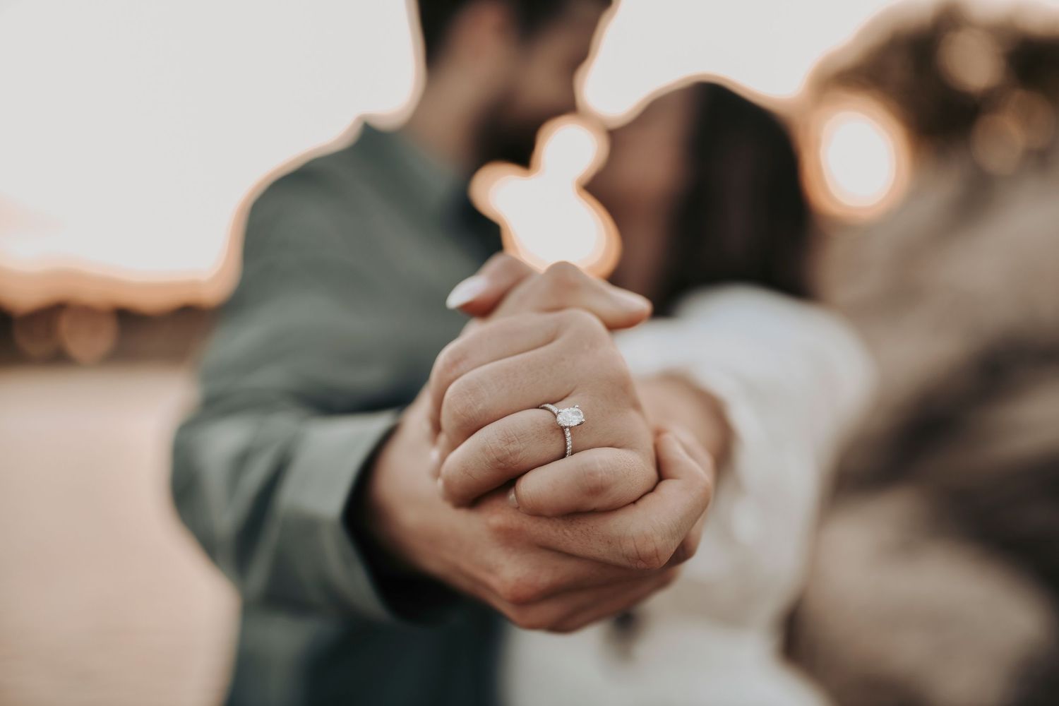 a couple dances and shares a kiss as they show off her engagement ring diamond during their engagement photos