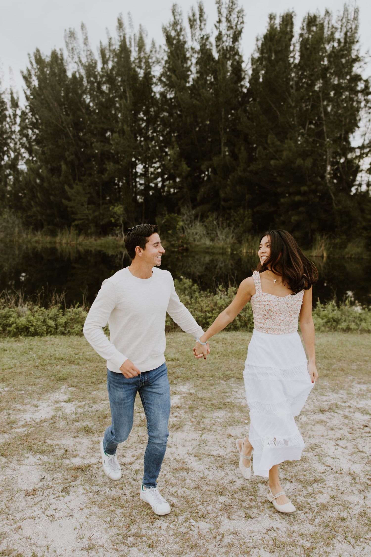Woodsy couple photos at the West Delray Regional Park with a lake and tall trees during golden hour captured by Lindsay McDow Photography.