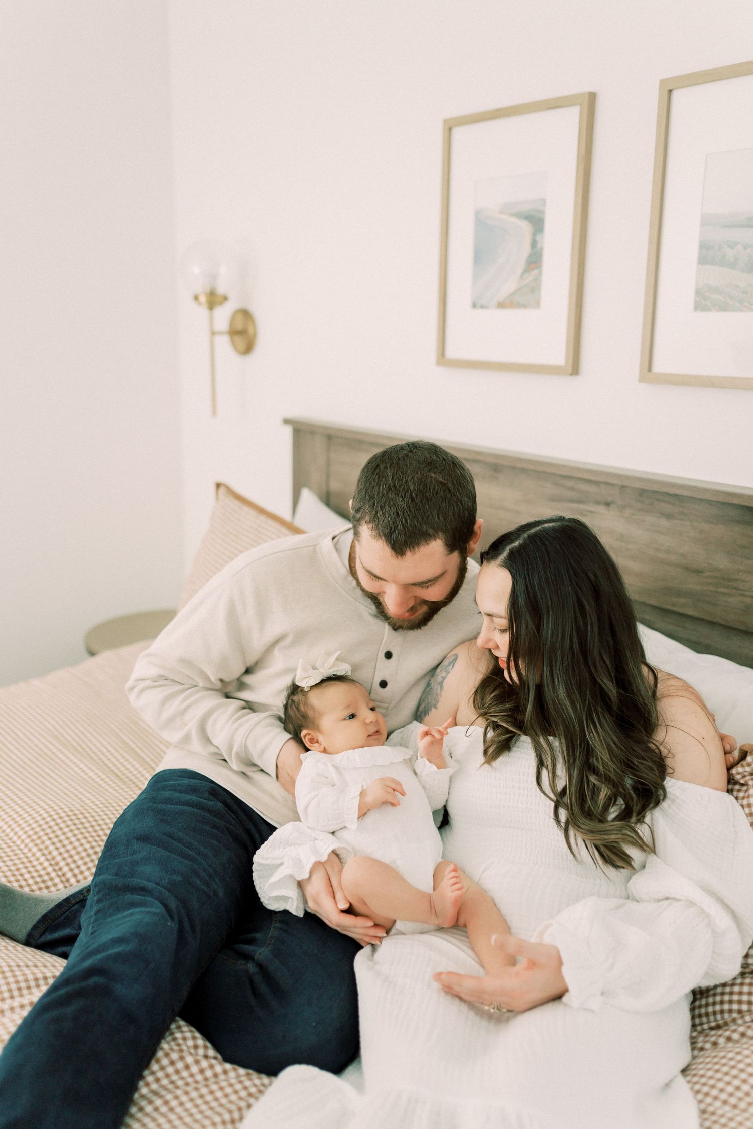 Family sharing intimate moment together on bed with infant.