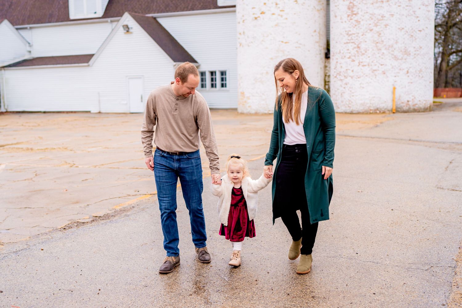 A family walking together on a concrete surface near a white building.