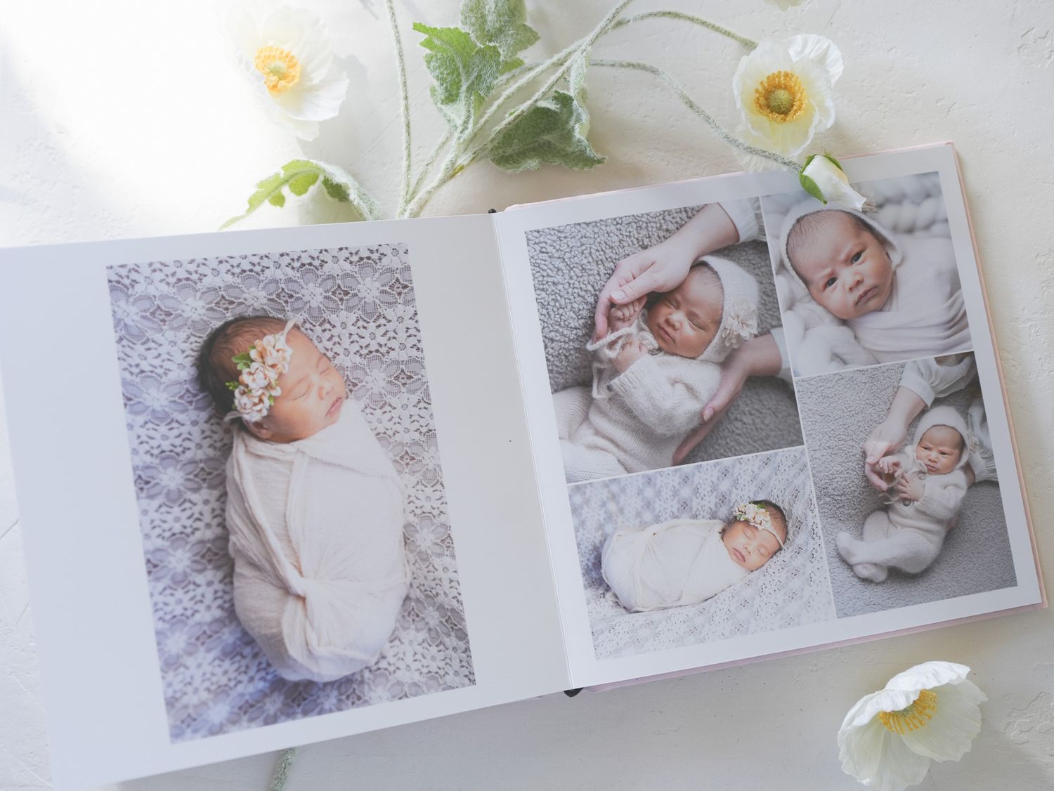 Baby photo album spread featuring infant portraits against delicate lace backgrounds.