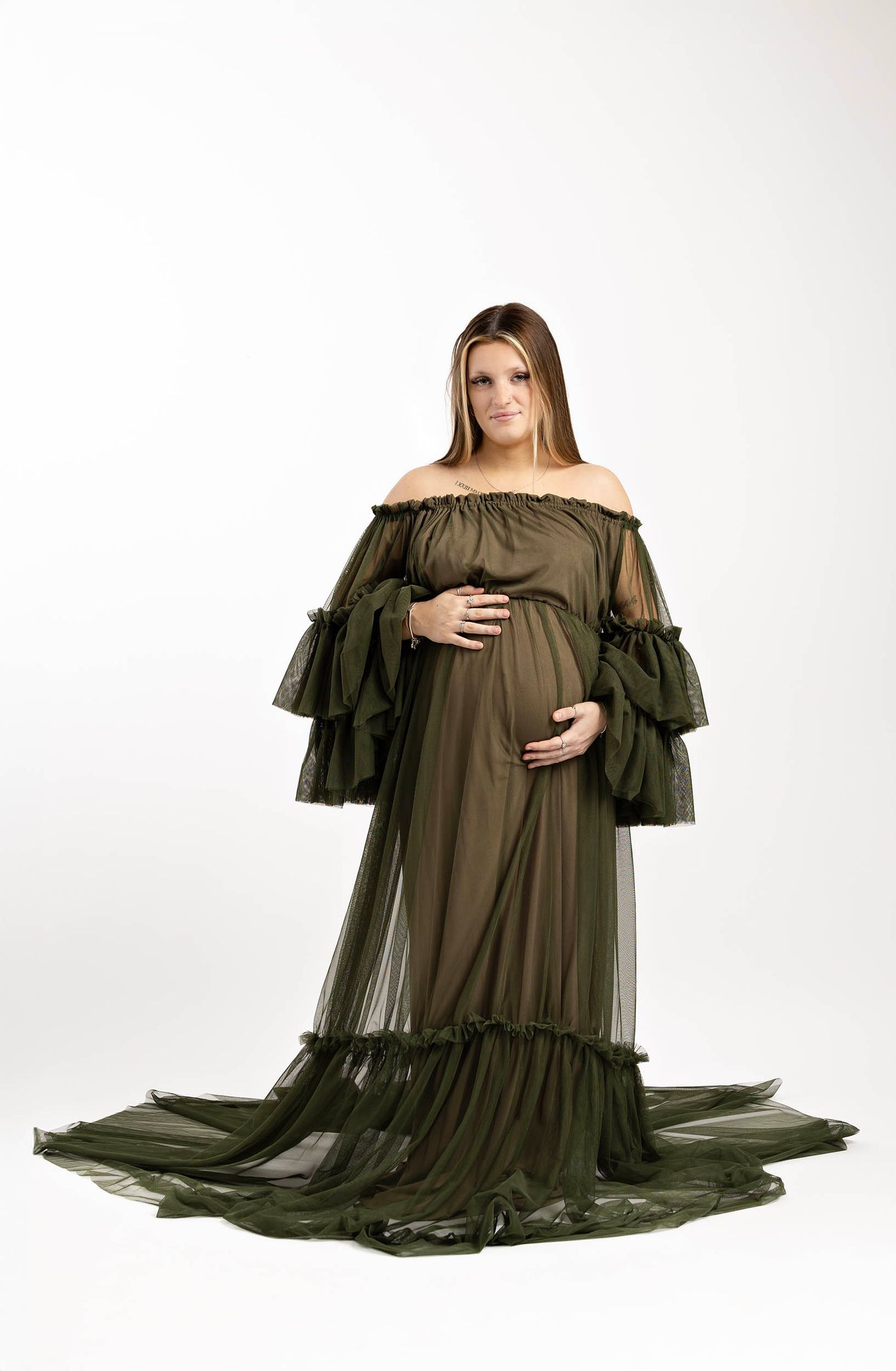 Maternity gown with ruffled sleeves and flowing train against white background. Pregnancy journey maternity photography in Gosport Hampshire