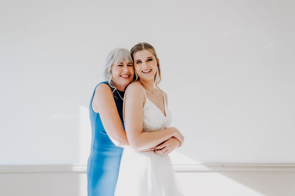 Mother and daughter share an emotional embrace during a wedding preparation moment.