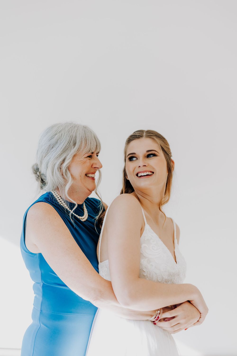 A touching moment shared between mother and daughter during wedding preparations.