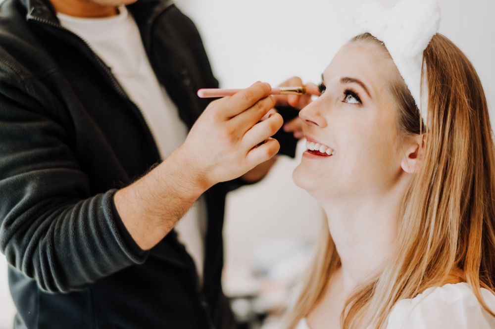Getting ready scene with makeup application during bridal preparations.
