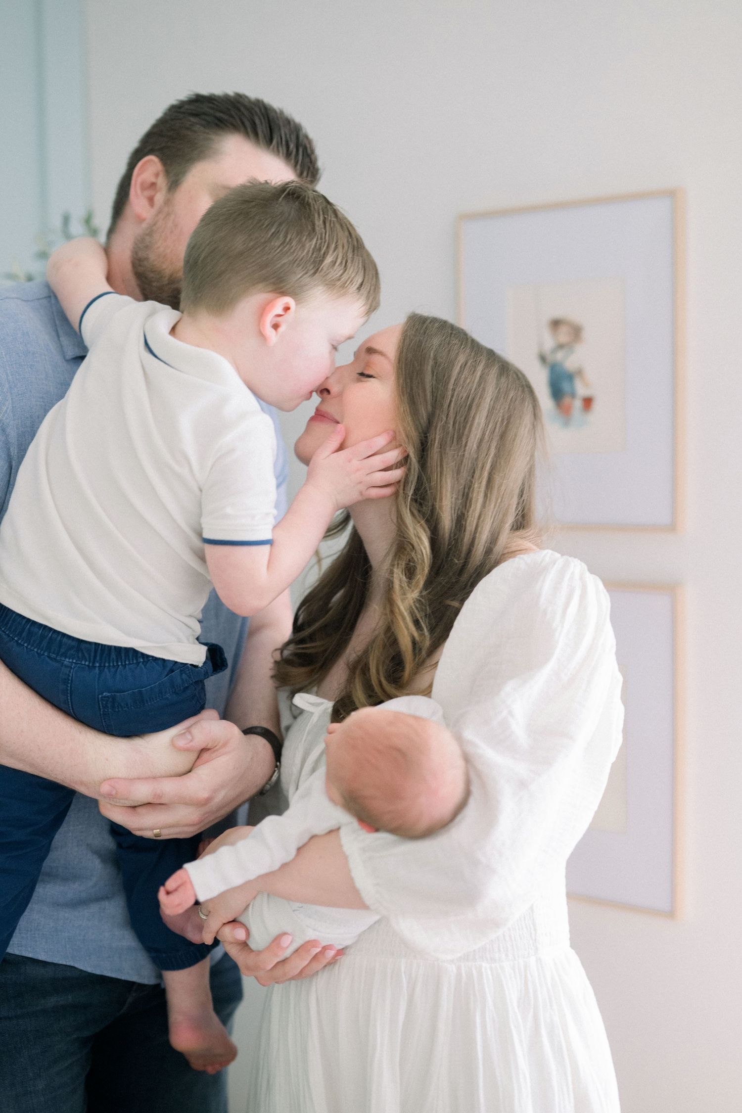 A series of intimate lifestyle family photos capturing tender moments in a bright, minimalist setting.