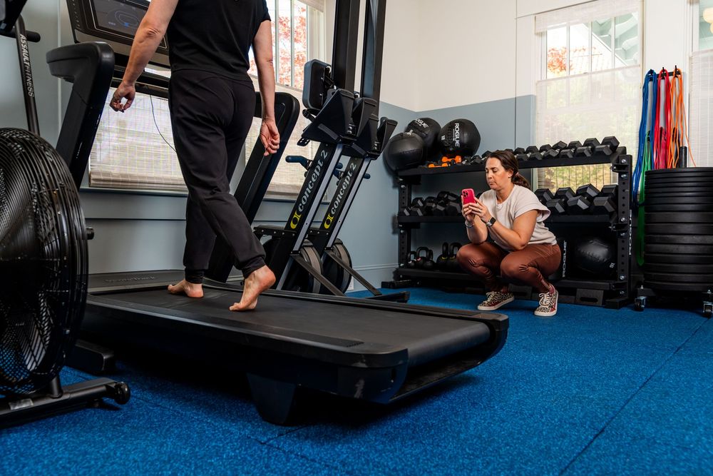 People exercising and stretching on blue carpeted floor in a fitness room.