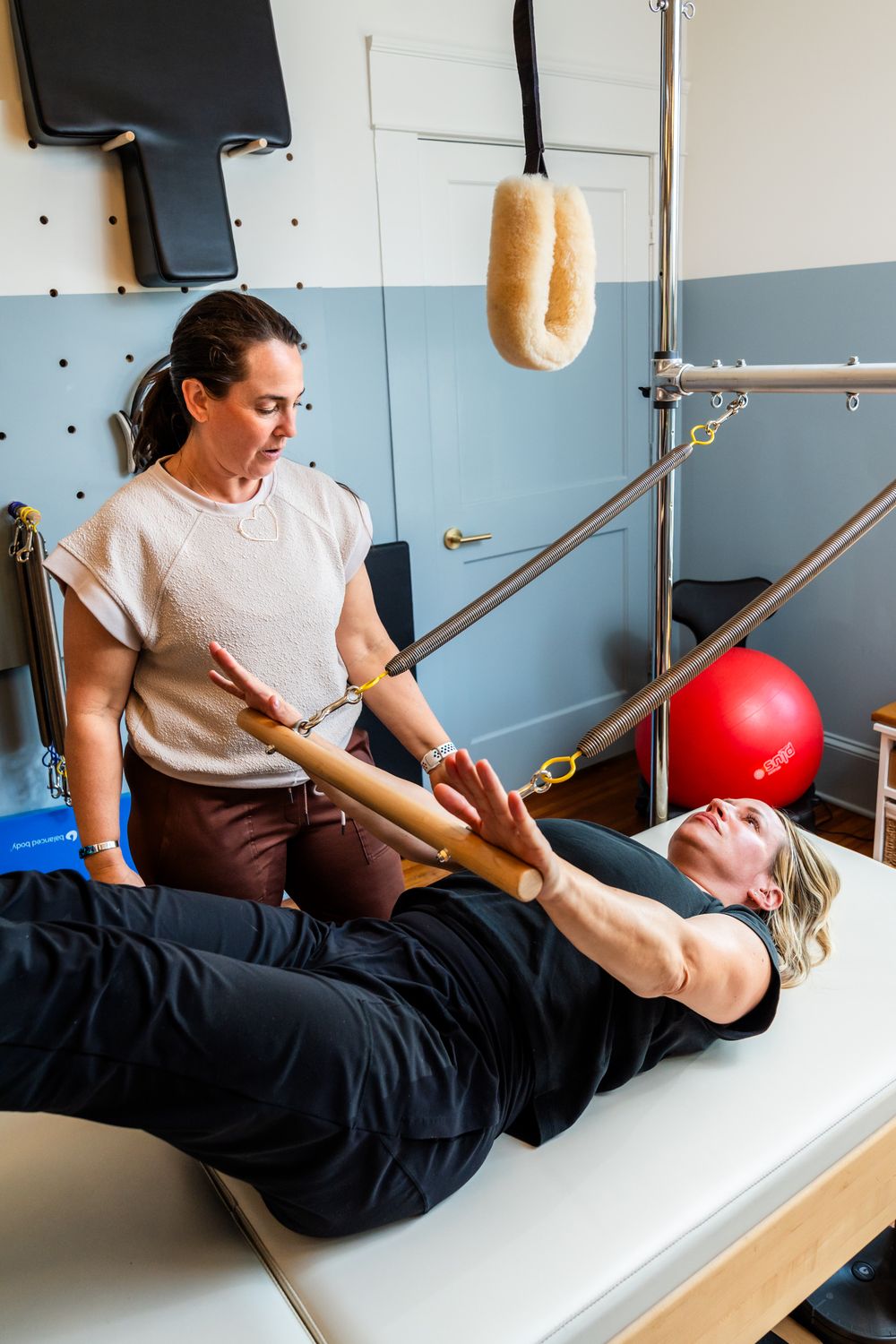 Healthcare provider demonstrates therapeutic stretching techniques on padded treatment table.