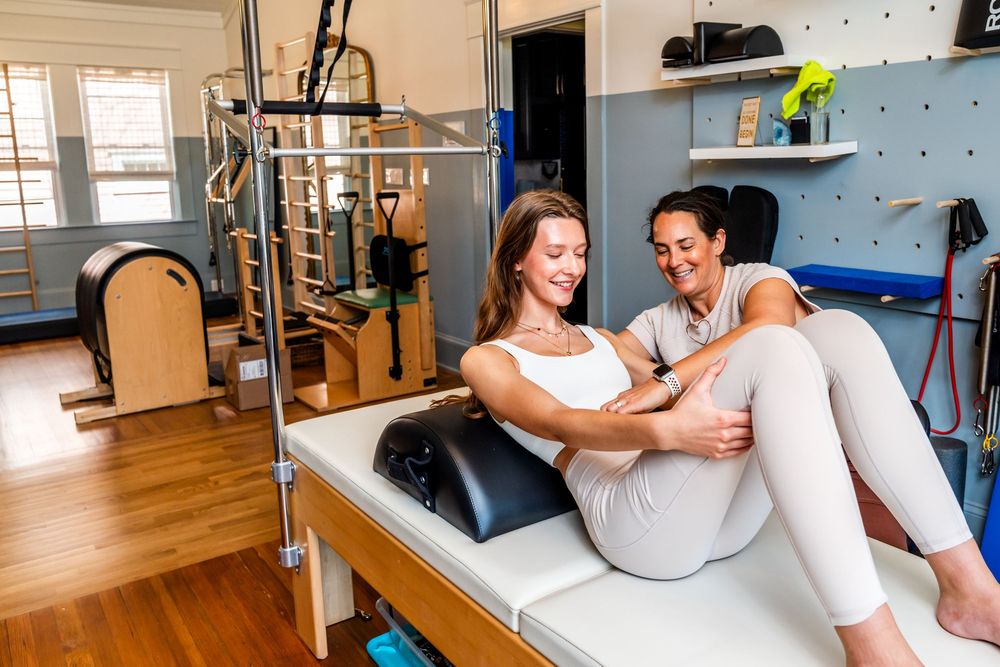 Therapist guides rehabilitation exercises on treatment table in modern medical facility.